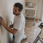 ps peinture à Nice : artisan ponce un mur avant peinture